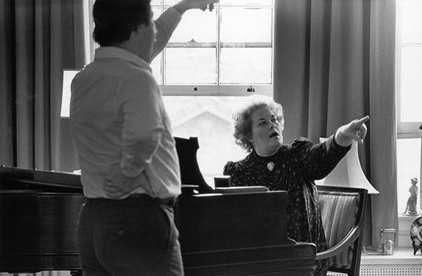 woman at piano teaching student to sing